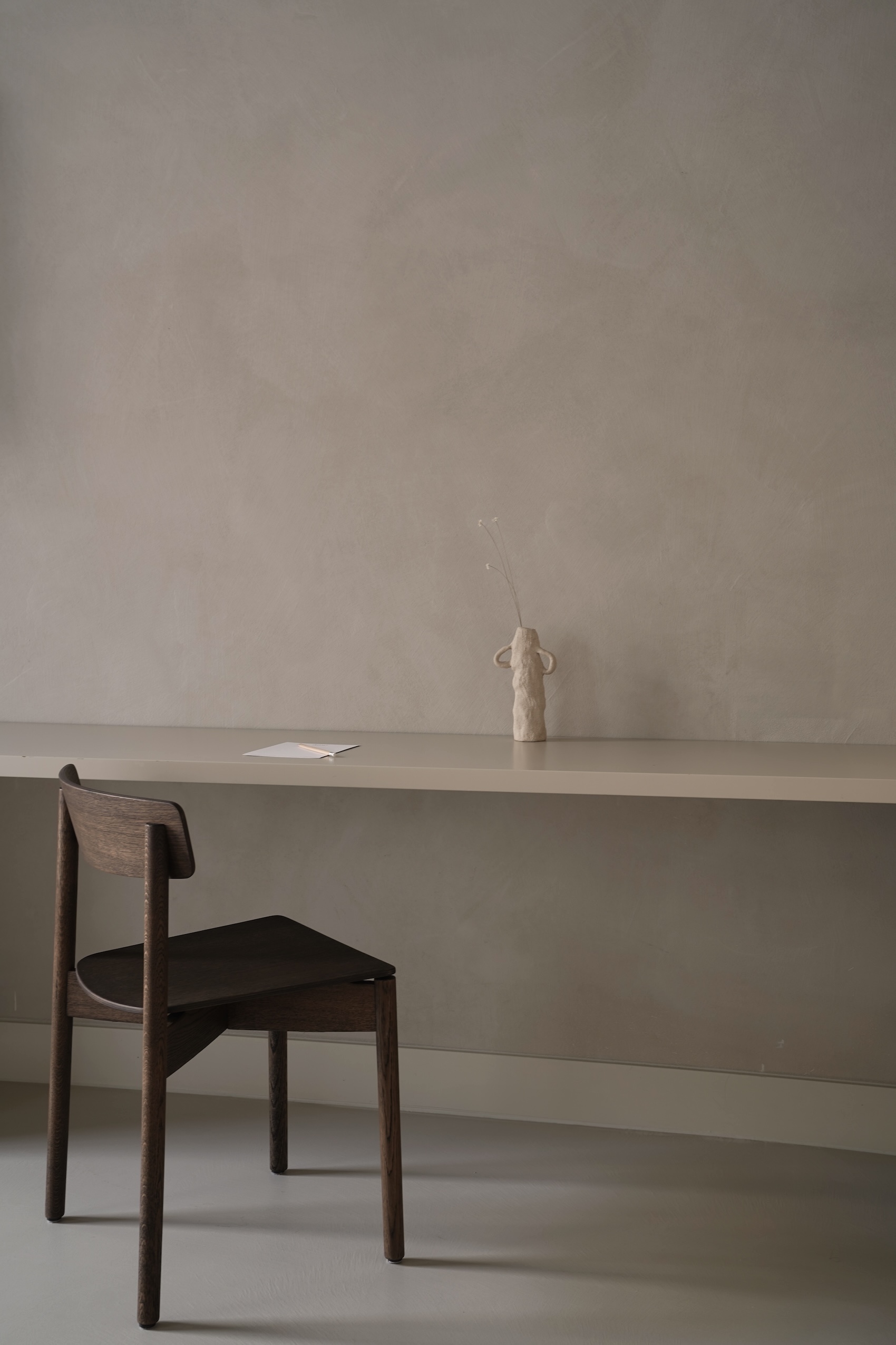 a desk extends from a standing wardrobe. the walls throughout are finished in w 23