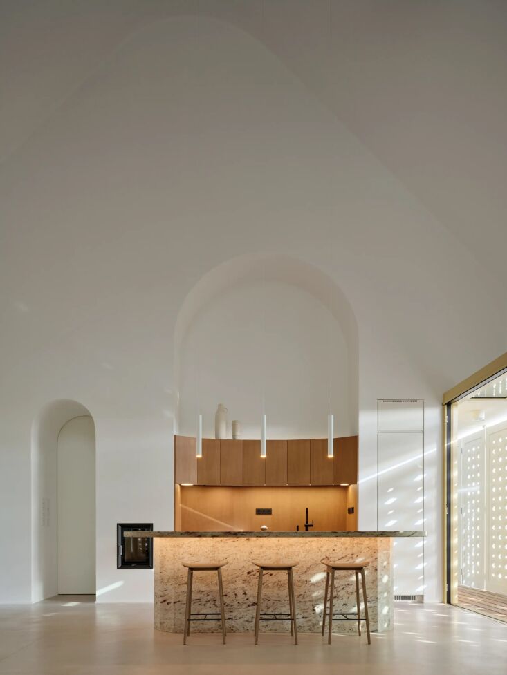 a curved wooden kitchen with an island made from indian shivakashi granite pair 23