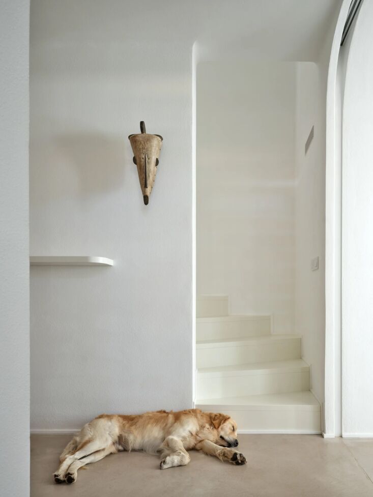 a traditional mask from gabon near a spiral stair leading to the upstairs bedro 24