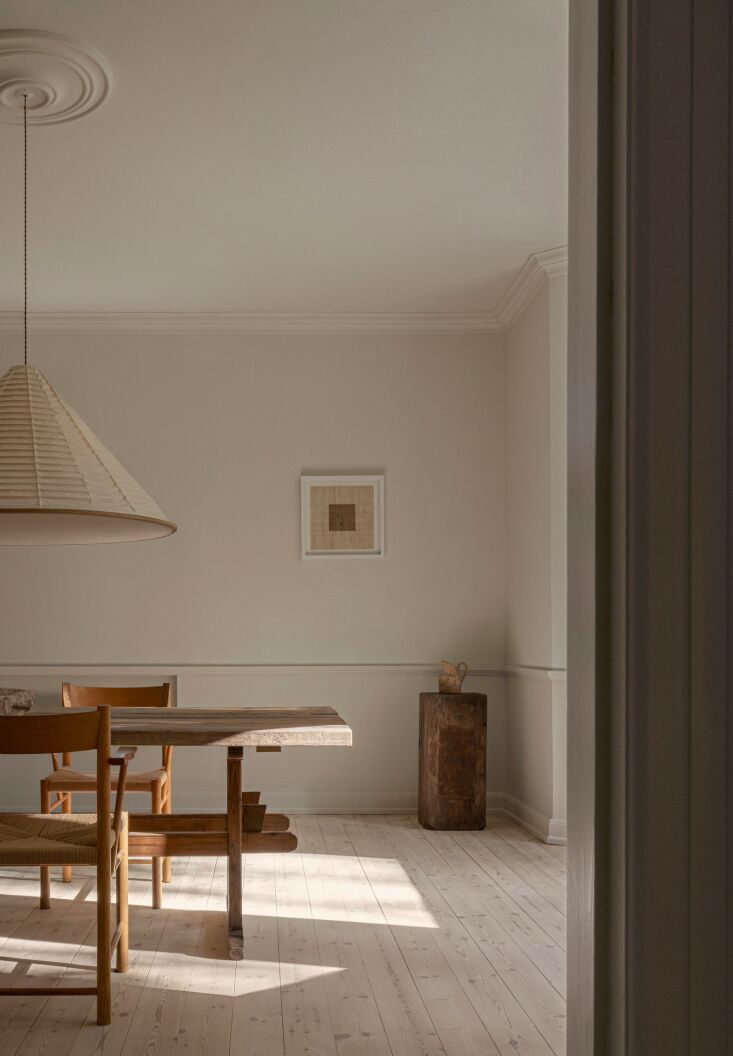 the norm architects n pl0\1 pendant lamp hangs above the dining room table. 21