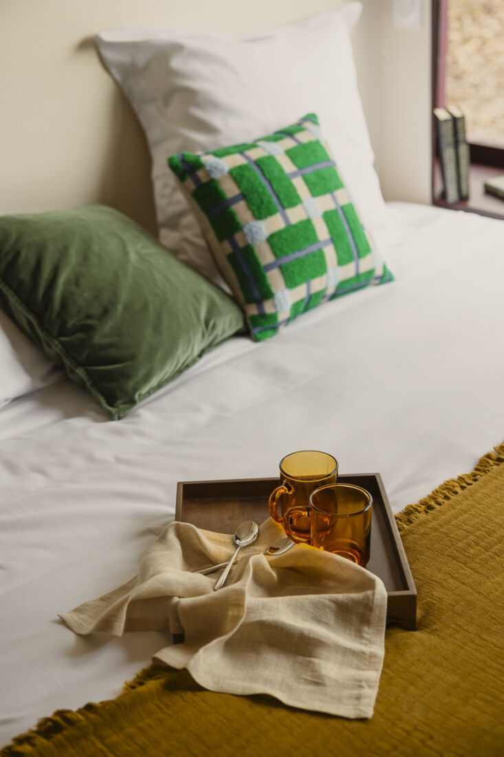 the bed is outfitted with a plano throw cushion from &k amsterdam and a woo 26