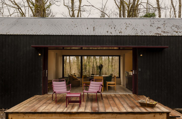 the wood terrace is equipped with burgundy colored outdoor furniture from the f 28
