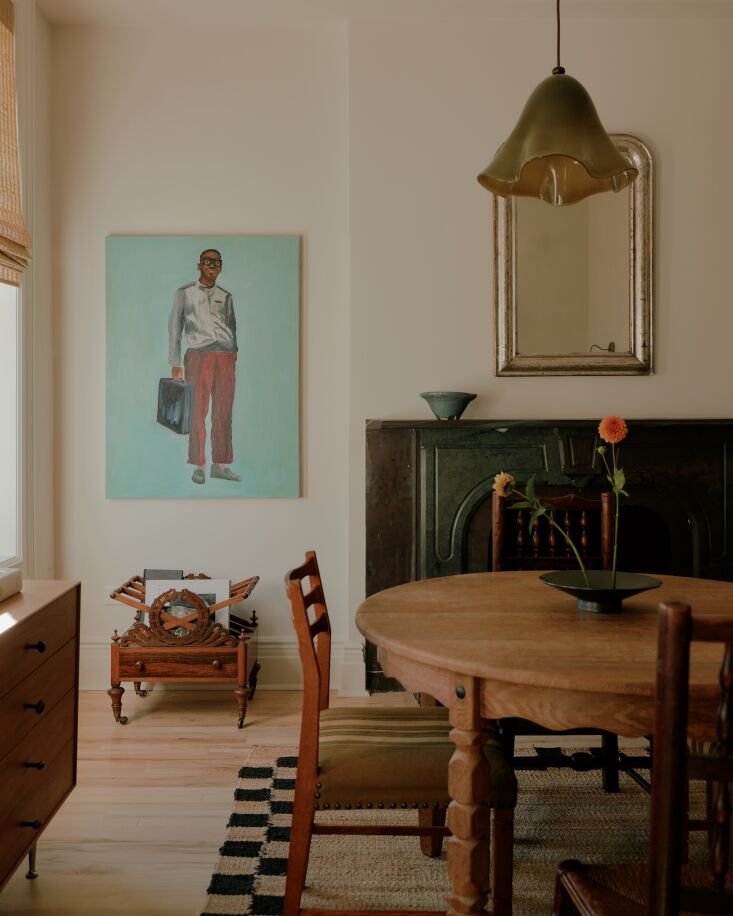 in a corner of the dining area, an arresting painting by sean pressley hangs ov 22