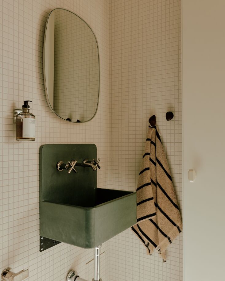 a concrete sink with a hint of green in the minimalist powder room. above it is 24