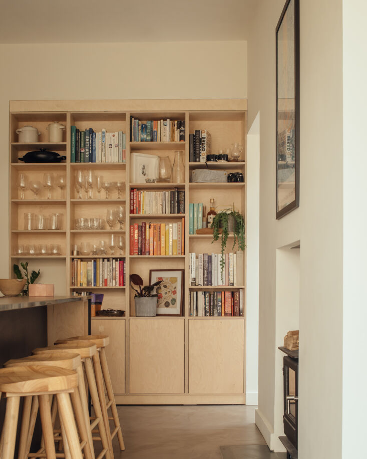 open storage displays cookbooks and glassware. the floors are made of microceme 24
