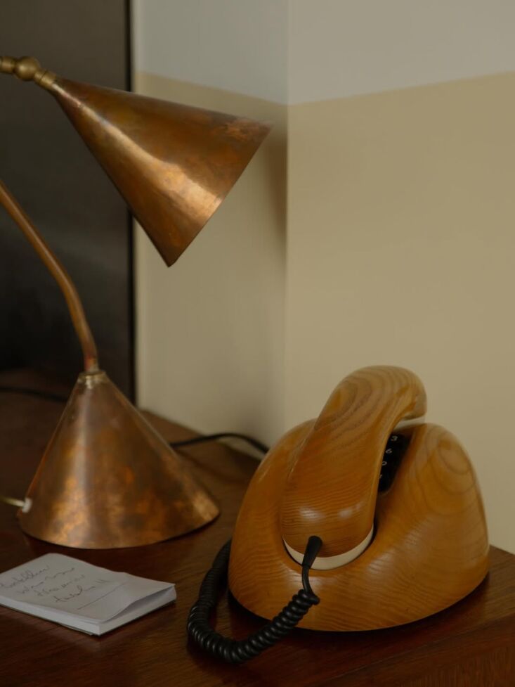 a brass lamp and german rotary telephone for taking reservations. 23