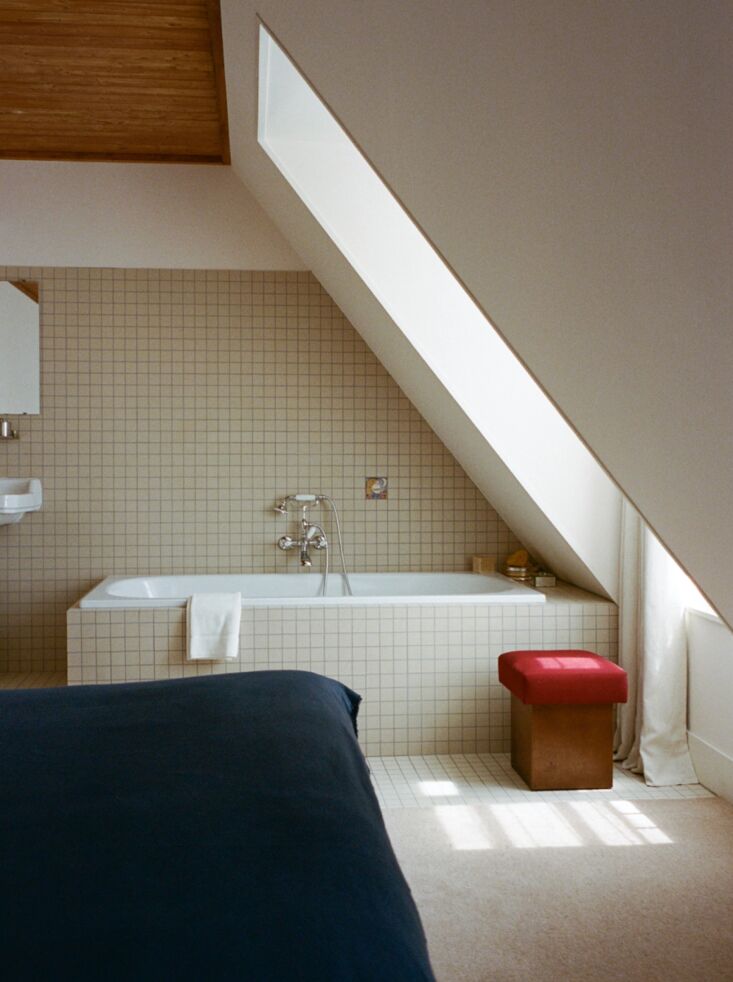 square tiled tub surround and walls in the deluxe room set under the eaves. 25