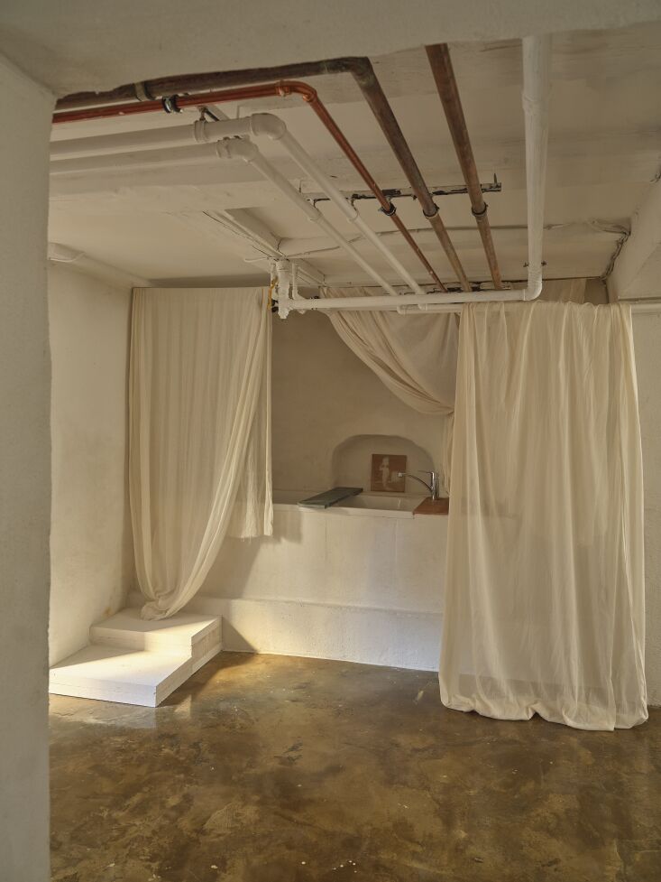 a bath enshrouded in curtains integrated in exposed plumbing. 25