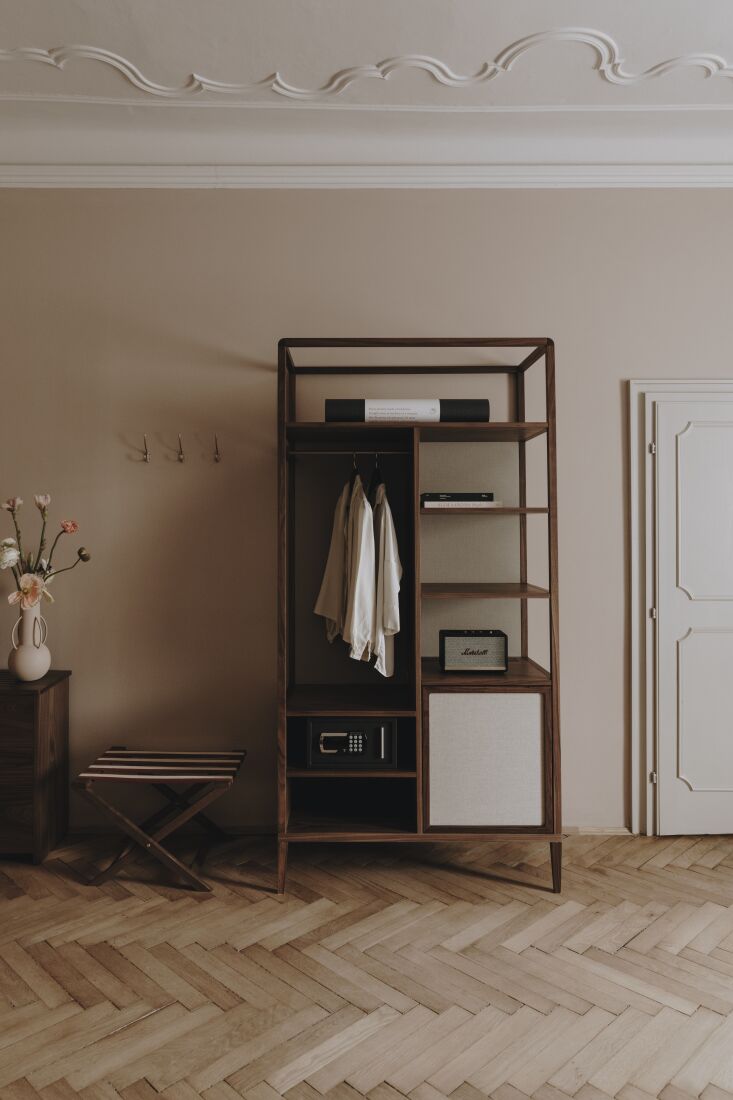 a custom storage unit in dark wood and striped luggage rack. 31