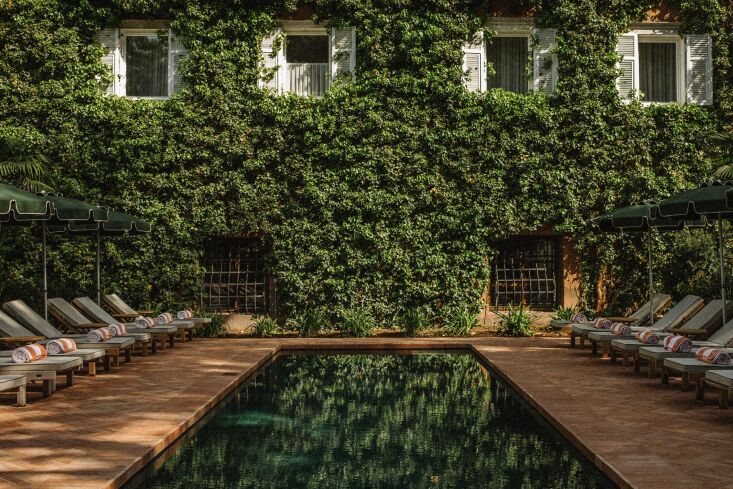 a large private park surrounds the hotel and an outdoor pool is lined in dark g 38