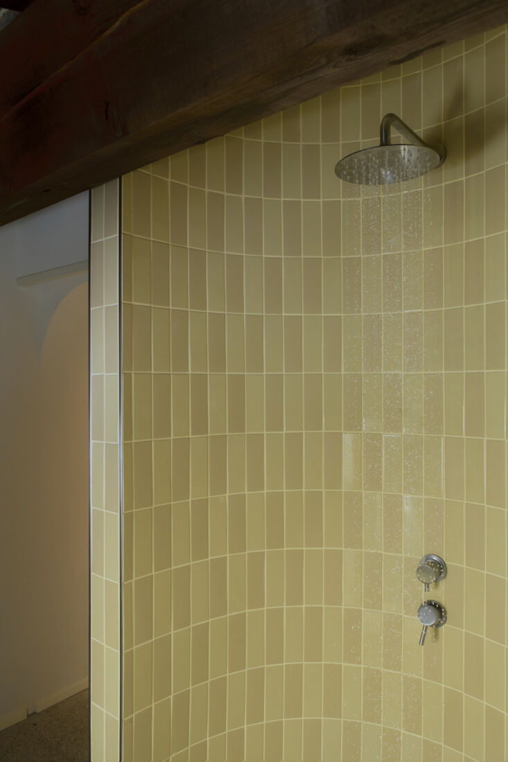 a curved shower wall is tiled in colorful rectangular tiles from quintessenza c 26