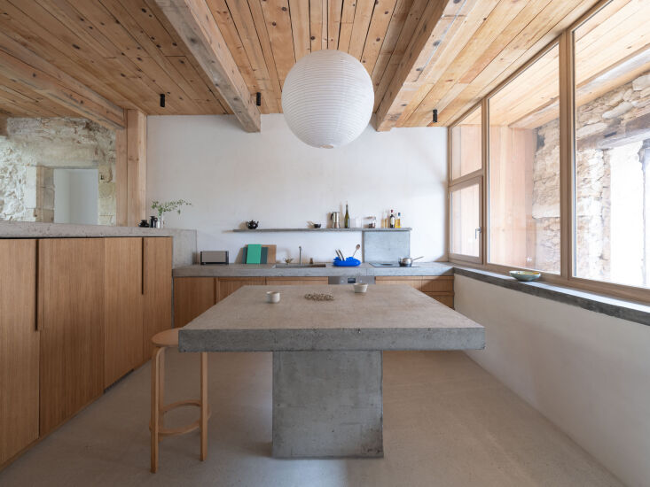 the entry opens into a kitchen constructed with oak cabinet fronts and a concre 19