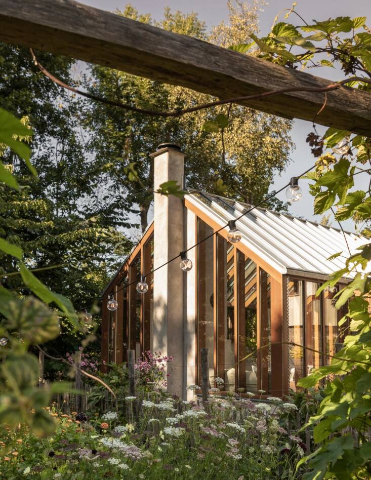 the orangery is surrounded by wildflowers and trees. 25