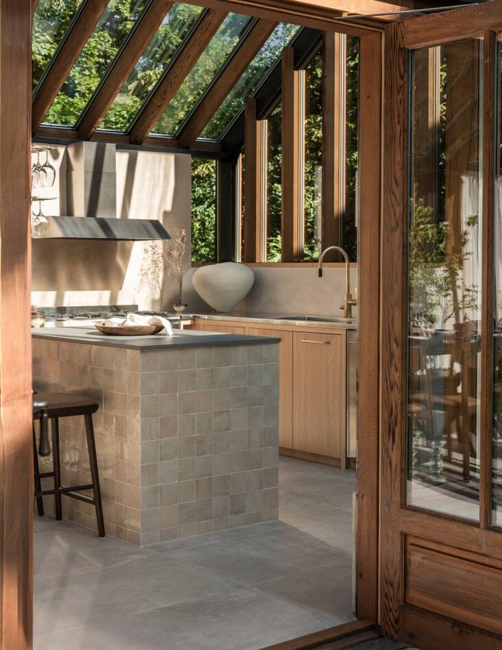 on one end of the room is a small u shaped kitchen. handmade french tiles cover 18