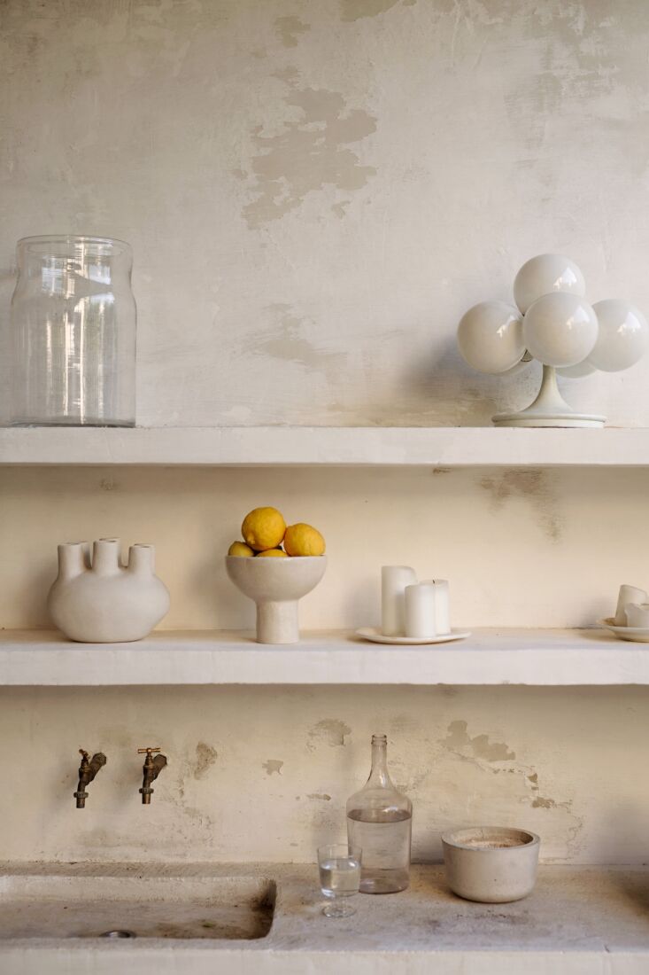 an adjacent outdoor kitchen of microcement with garden taps is used during the 21