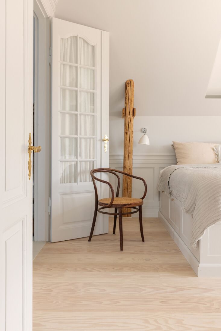 a bedroom with a custom built in bed designed to maximize storage. a gubi wall  24