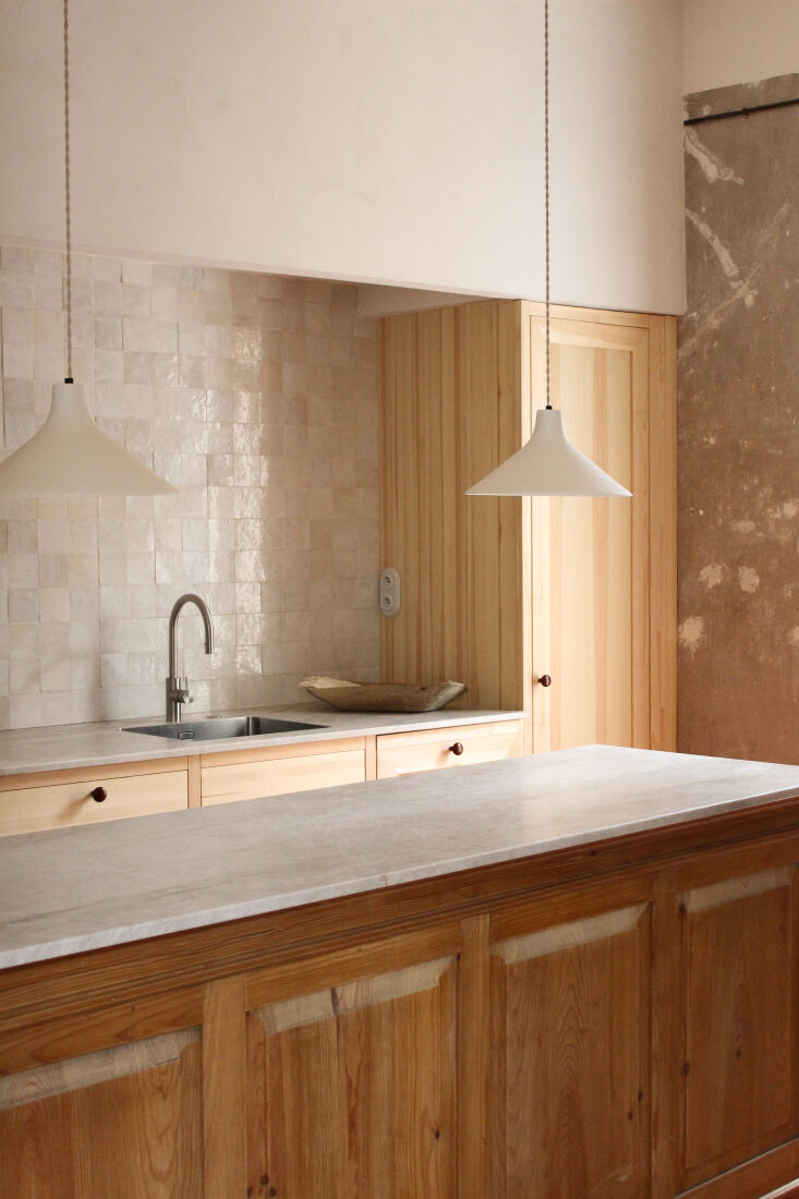 a kitchen designed in reclaimed wood and raw pine with stone counters, zellige 17