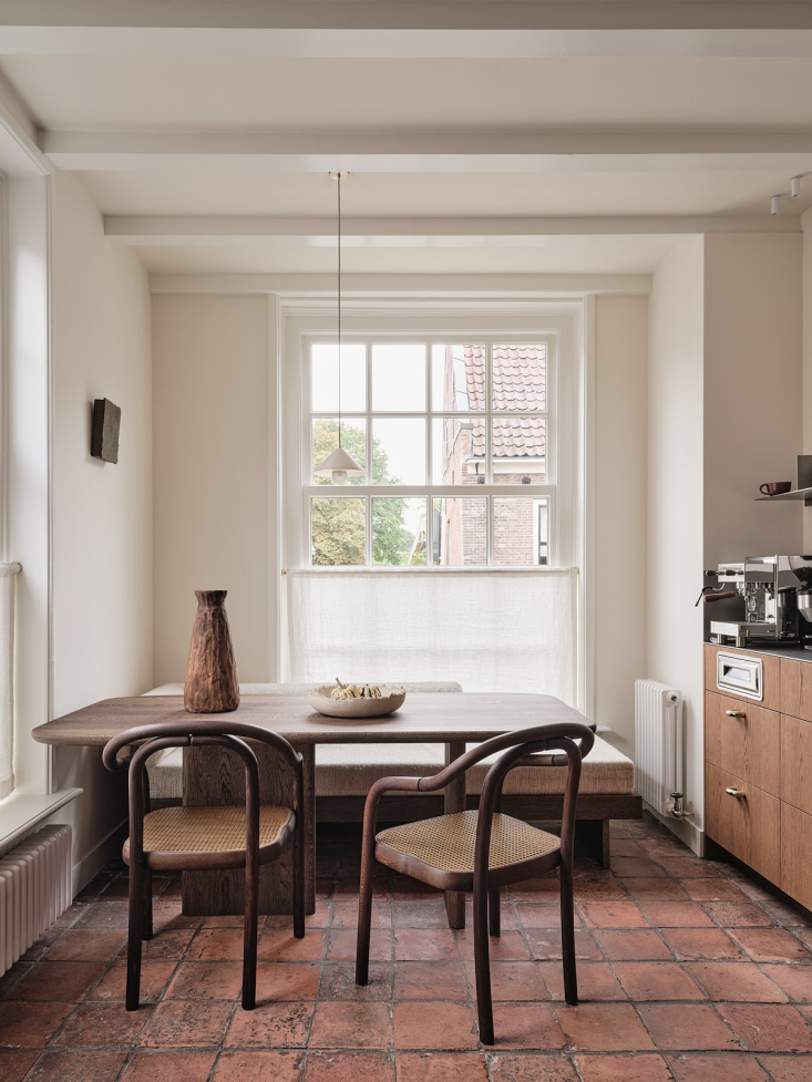 the original farmhouse tiles are in tact. the walnut table and built in sofa ar 17