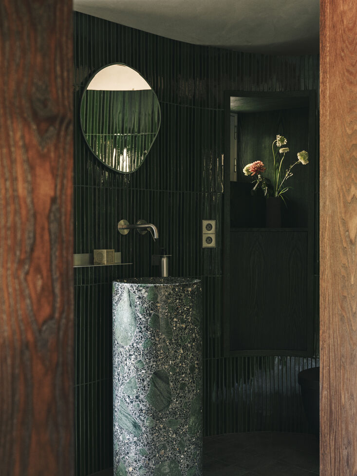 a green bath marked with a custom marble pedestal sink, thin vertically laid hi 28