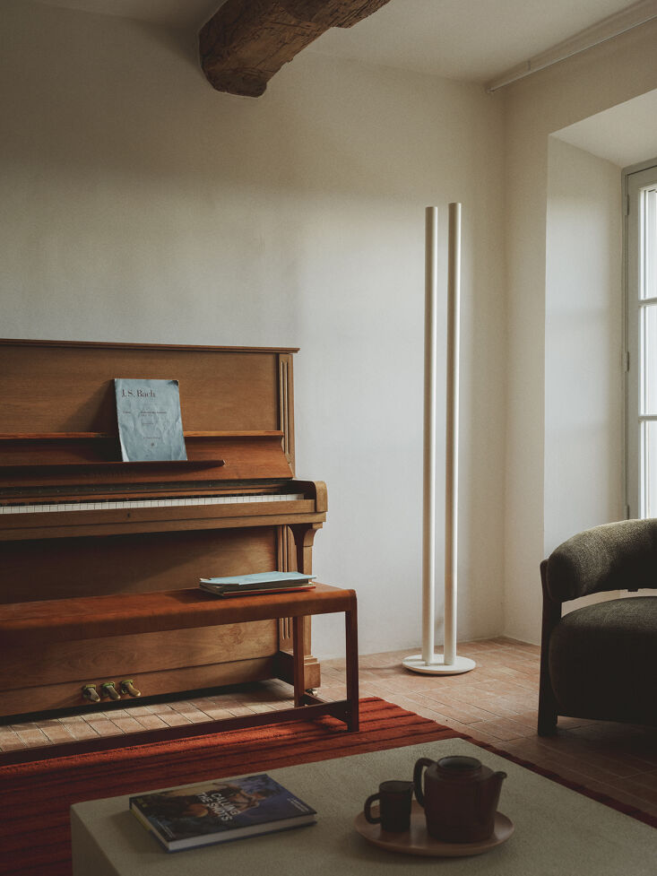 the frama bench 0\1 in warm brown birch serves as a piano seat and the floor la 18