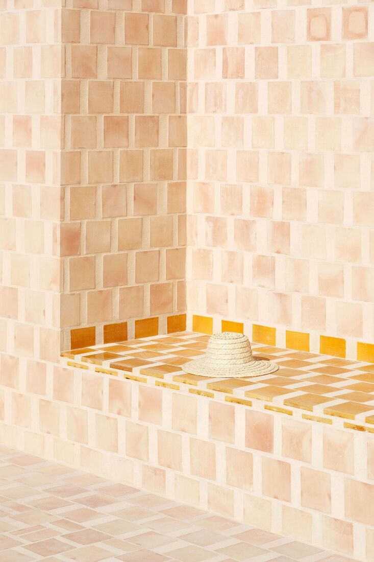 contrasting terracotta tiles highlight a built in bench. the apartments are ava 27