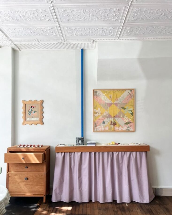 a tiled and skirted fir shelf covers a radiator in the studio—the wood frame 25