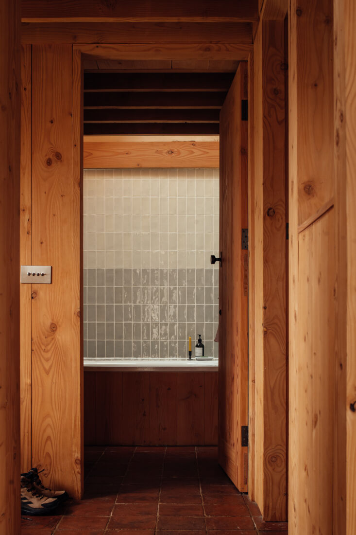 leading from the central living and kitchen room into the bathroom, a material  26