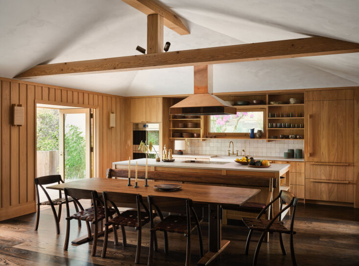 tripp carpenter created the claro walnut trestle dining table, and both the din 23