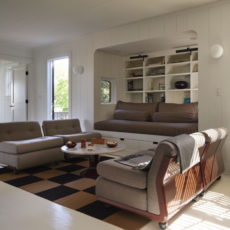 in the parlor room, a nordic knots square flatweave rug is framed by two mario  24