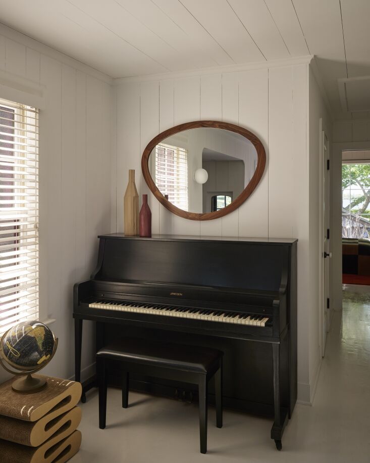 an upright piano, porada giolino mirror, and the frank gehry wiggle stool. 26