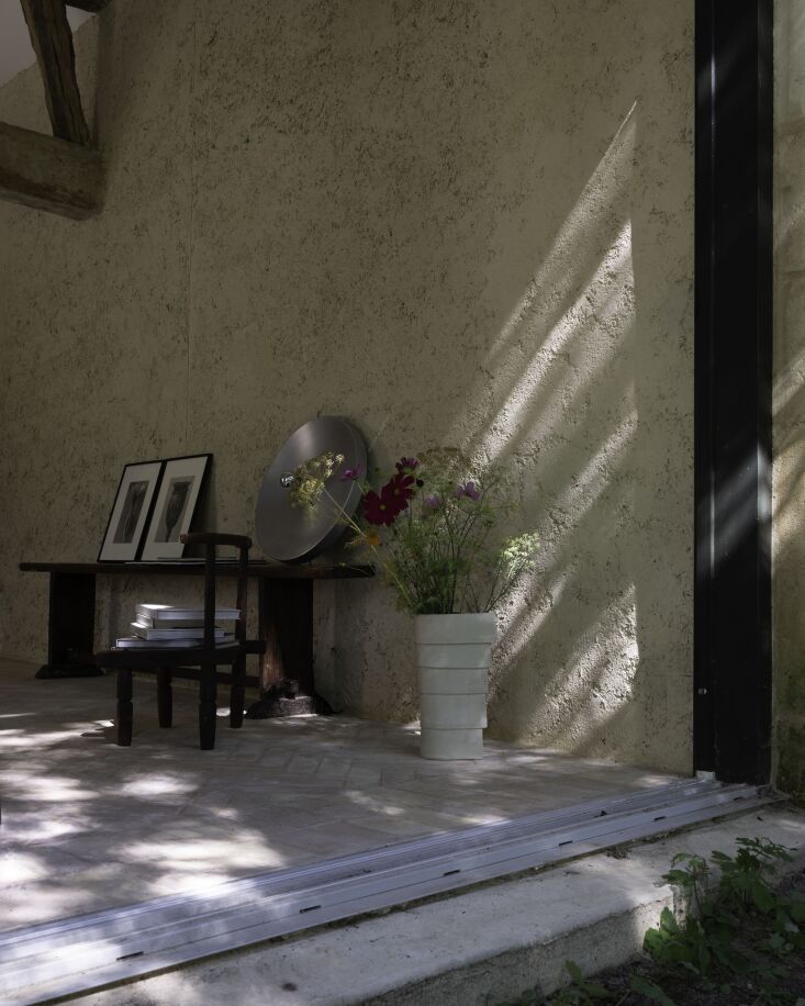 the back wall is a floor to ceiling sliding door that opens into the garden. a 21