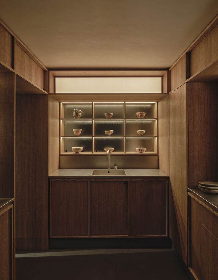 in a nod to japanese shoji screens, a grid of shelves in the kitchen is backed 26