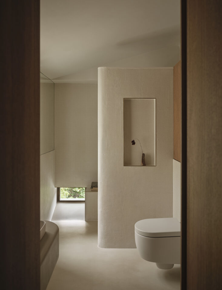 a small window at the bottom of the shower offers a peek of greenery—but that 25