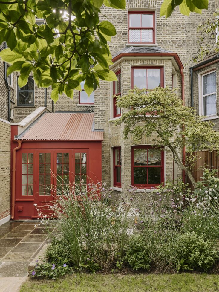 the front door and exterior accents are painted in bronze red by little greene. 17