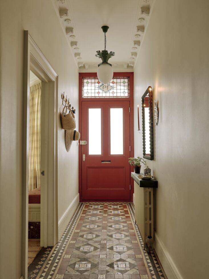the hallway is lit by a pair of dodo egg light pendants by beata heuman and the 18