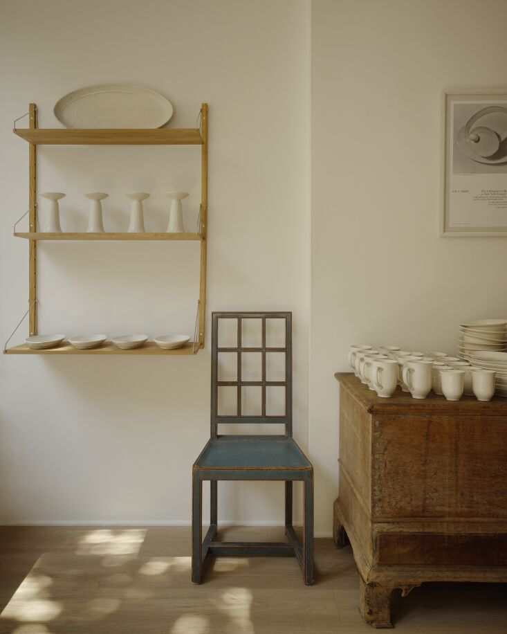 tall taper candleholders, \$\250, on oak shelves by frama and a lineup of mugs, 21