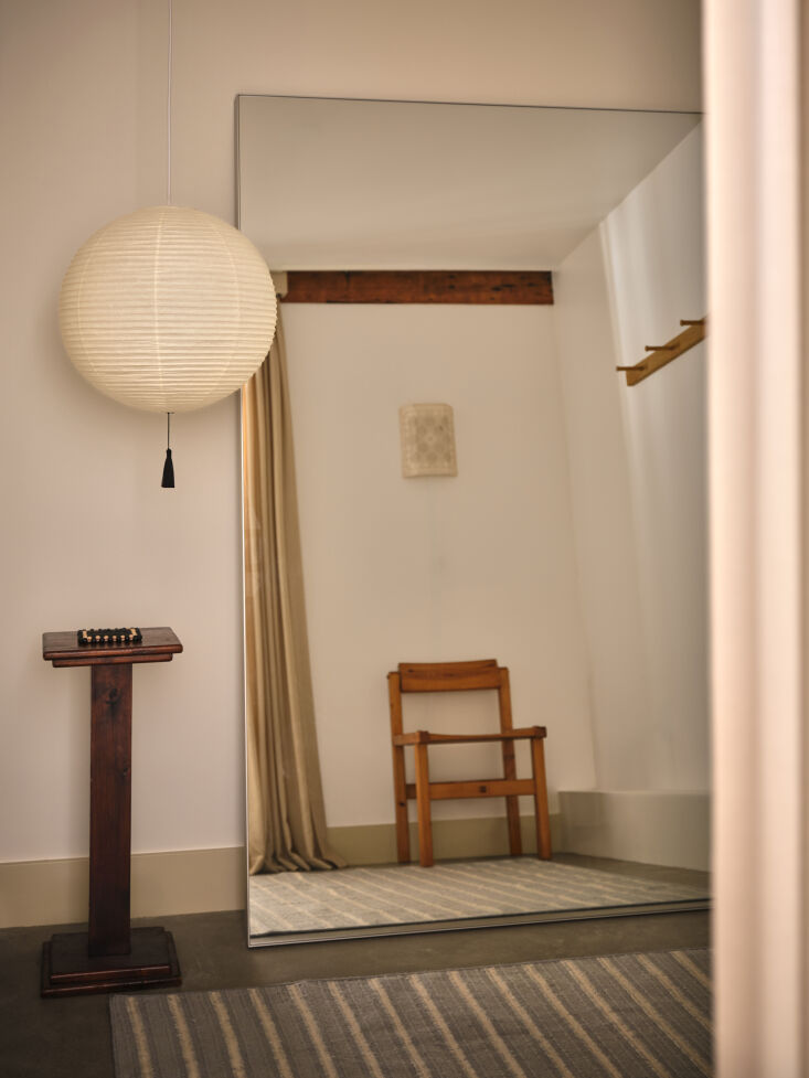 a small changing room is designed with an isamu noguchi akari 45a pendant that 26
