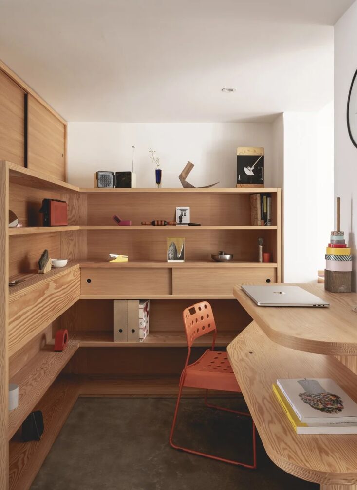 built in shelving and an orange omk stak \1.\1 chair. 24