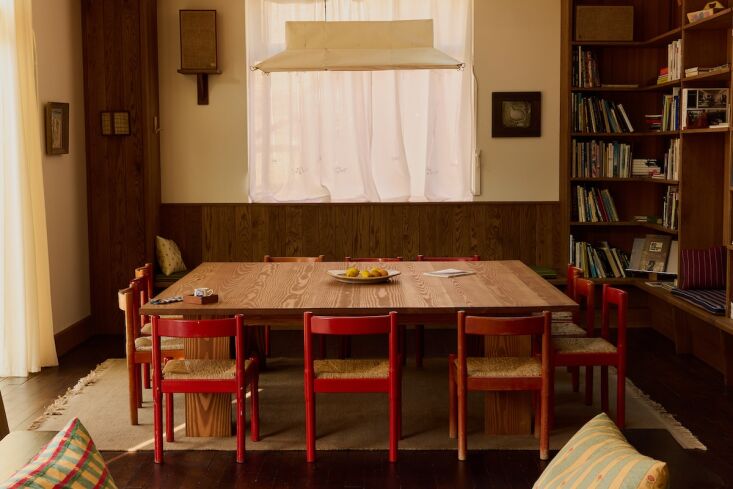 an 8 by 8 foot douglas fir table and vico magistretti’s \1960s carimate chair 30