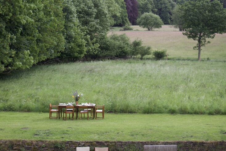 a farm lunch is set with wooden tables and chairs in the property\2\17;s 20